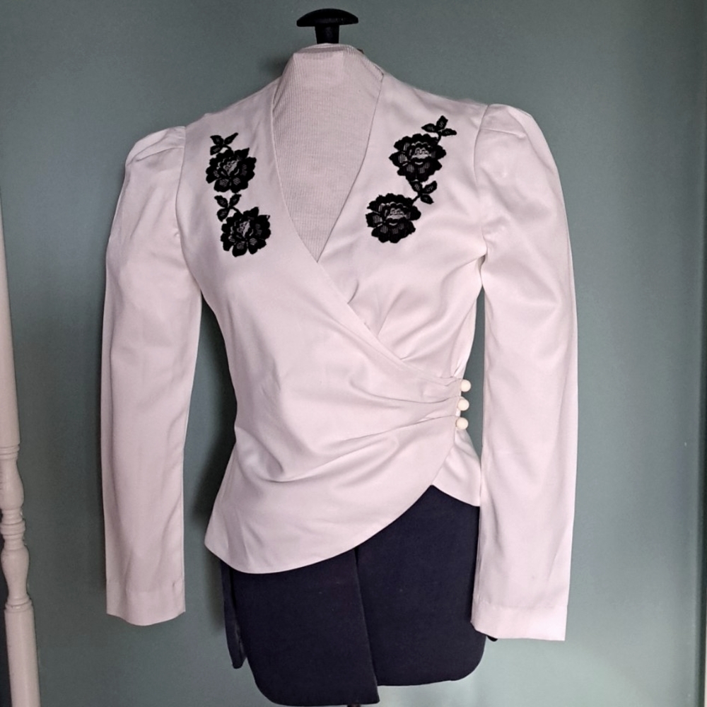 Custom design white satin peplum top with black lace appliques.